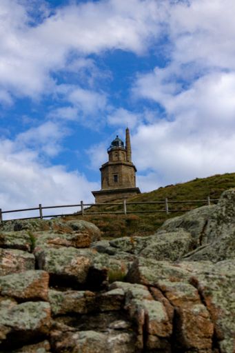 A vertical low angle shot of the Tower of Hercules in Spain captured during the daytime