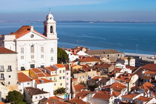 A beautiful cityscape view of the Alfama neighborhood in the city of Lisbon with sea in background