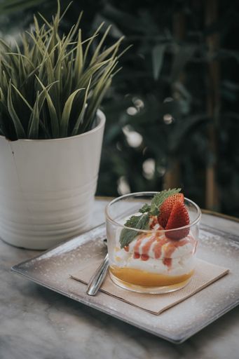 A vertical shot of fresh summer dessert with strawberries in a glass in a restaurant