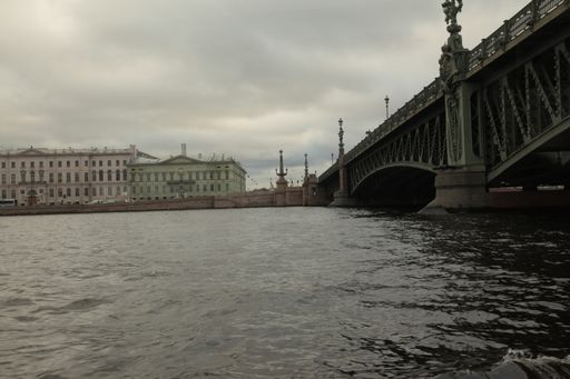 A beautiful view of the river, bridge and buildings in St. Peterburg under the cloudy sky