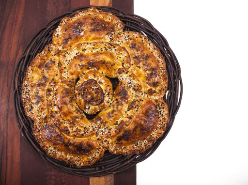 A high angle shot of a flower-shaped homemade pizza on a wooden surface