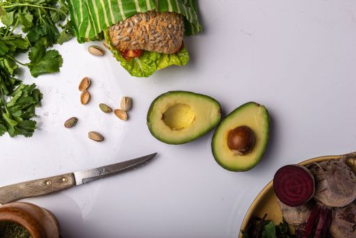A bowl of freshly chopped assorted vegetables and avocados atop a white surface