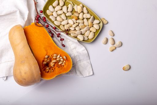 A top view of a butternut squash with seeds on a white background