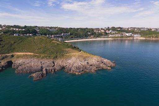 A high angle shot of the beautiful Langland Bay beach with blue water and clear sky
