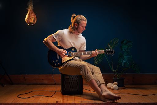 A young caucasian man playing an electric guitar on a stage
