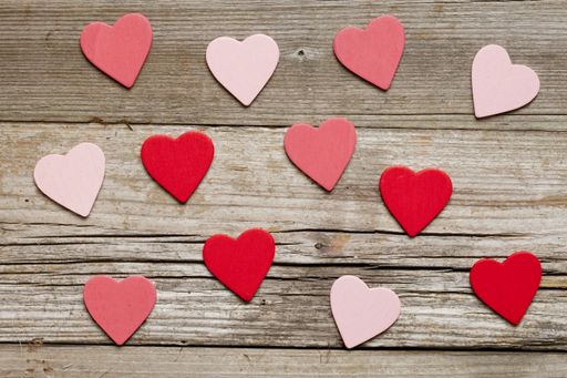 A top view of colorful heart cutouts on a wooden background