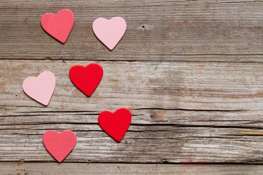 An overhead shot of heart shaped decorations for Valentine's day on a wooden surface