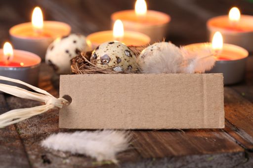 A blank tag on a table surrounded by burning aromatic candles