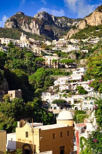 A vertical shot of the village houses on a mountain surrounded with greenery in Positano, Italy