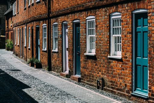A brick building on a cobblestone street with wooden doors and white windows in Farnham, England