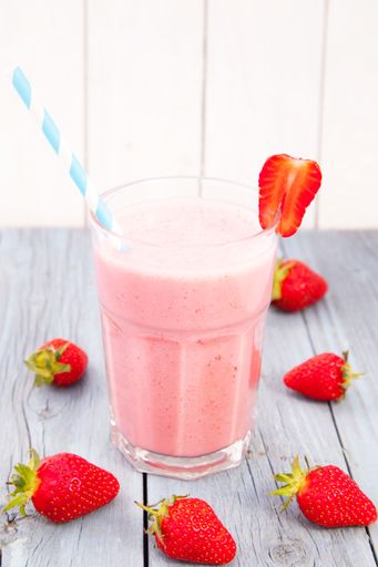 A vertical closeup shot of a strawberry smoothie on the table