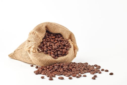 Colombian coffee beans in a burlap bag and on the floor isolated on the white background