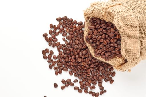 a top view of Colombian coffee beans in a burlap bag and on the floor isolated on the white background