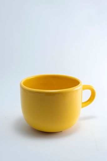 A vertical shot of a yellow cup isolated on the white background