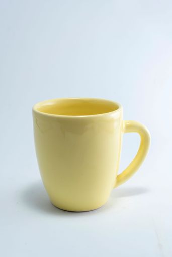 A vertical shot of a yellow cup isolated on the white background