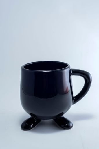 A vertical shot of a black cup isolated on the white background