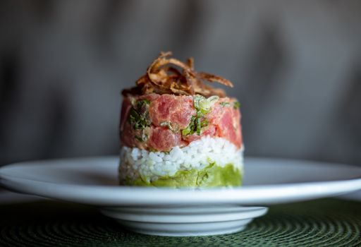 A plate of tasty salmon, rice and avocado tartare