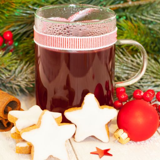 A selective focus shot of a cup of tea with cinnamon sticks and cookies on a Christmas theme background