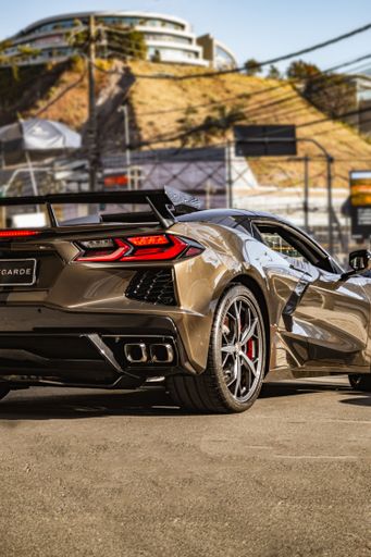 a vertical rear view of a grey Chevrolet corvette c8 on the road