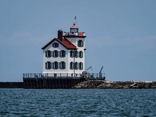 A lighthouse at Lake Erie on the Ohio Coast looking over rough water, USA