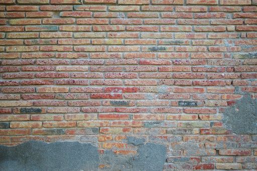 A red old and weathered brick wall