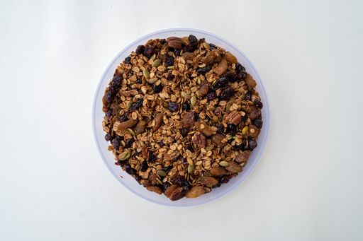 A top view of a bowl of chocolate and coffee oat granola over a white background