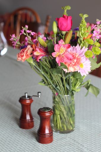 A vertical shot of a vase full of beautiful flower on a table