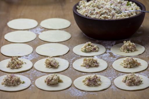 A high angle shot of a round dough filled with delicious fillings on a wooden surface