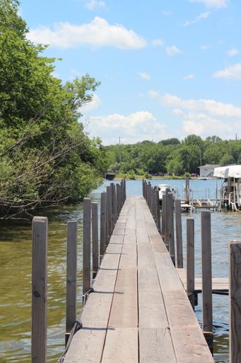 a vertical shot of a wooden pier over a lake taken in Iowa