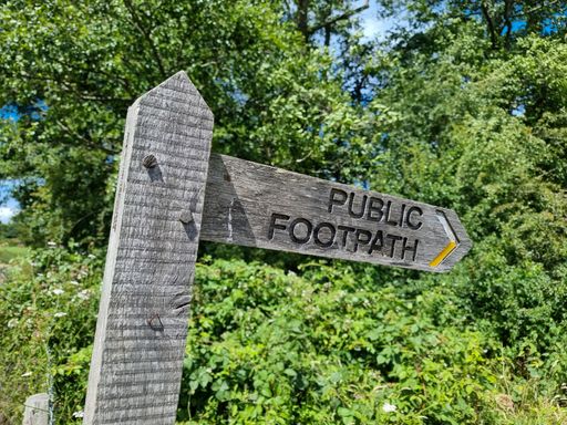 A public foot path sign showing the route of a hiking trail in England