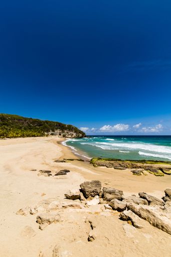 A gorgeous vertical shot of a sunny beach in San Juan, Puerto Rico under a clear blue sky in the summer