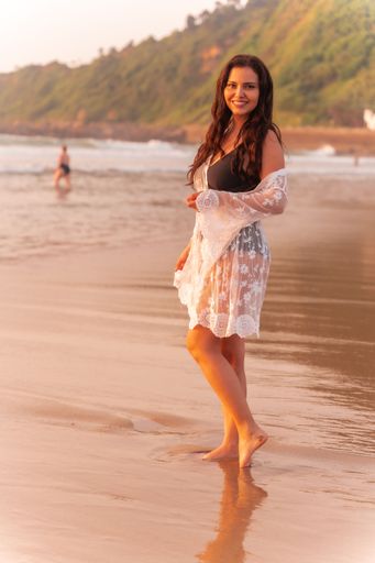 A portrait of a woman in a white dress enjoying her vacation during the sunset