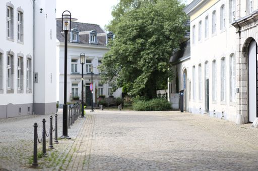A beautiful shot of a cobblestone path separated from a street with sidewalk fencing posts