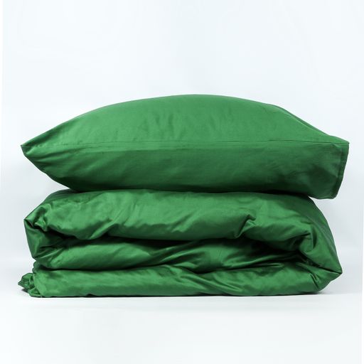 A closeup of a green pillow on a folded blanket isolated on a white background