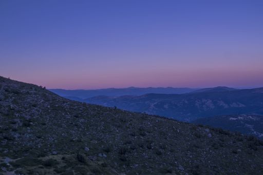 A beautiful view of the grass-covered hills captured at a colorful twilight