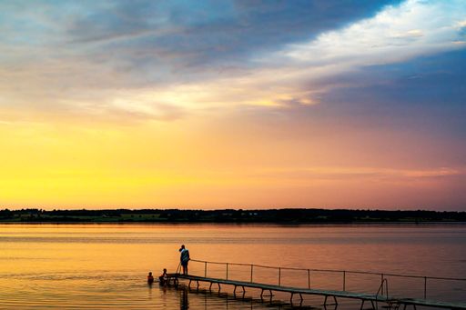 A family takes in the view of a lovely sunset from Stubbekobing in Denmark.