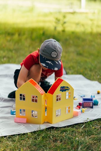 The vertical view of a child playing on the blanket over the green grass