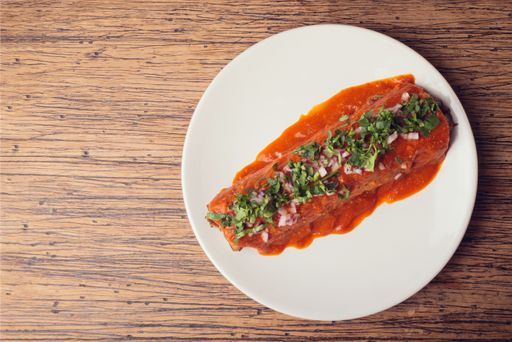 A top view of traditional Mexican gourmet food on a wooden table. Mexican burrito