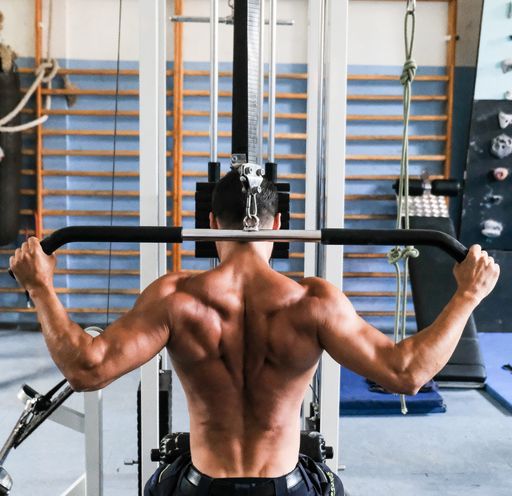 A closup shot of a man doing some weights in a gym