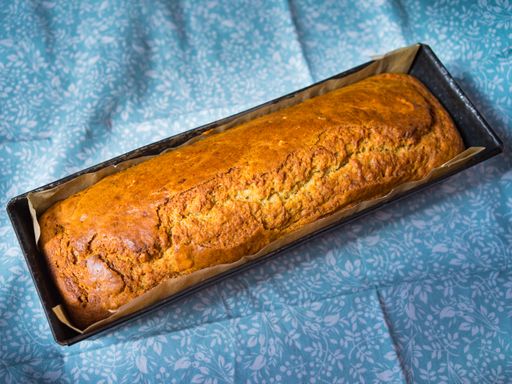 Freshly baked, natural homemade bread in a cake tin on a blue tablecloth