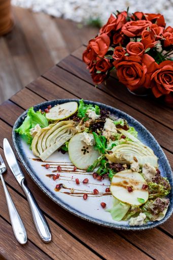 A vertical selective focus shot of vegetable salad on wooden table
