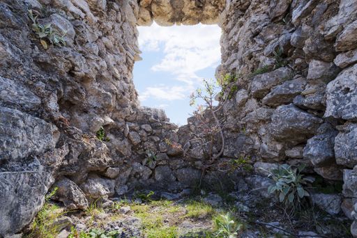 A low angle shot of a window of a rock structure