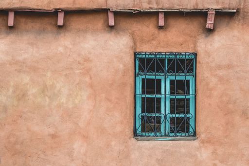 A simple little house with smooth brown walls and blue windows  in Santa Fe, New Mexico - Southwest architecture