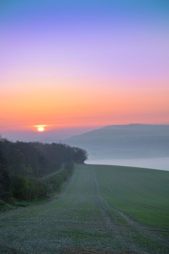 A golden sunrise over the valley with a foggy weather