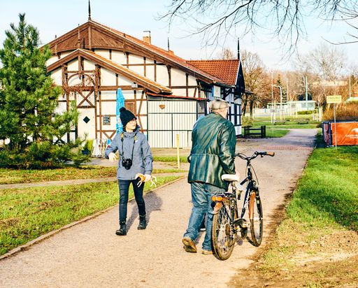 Man with bike and woman walking on a footpath at the Malta park on a sunny winter day