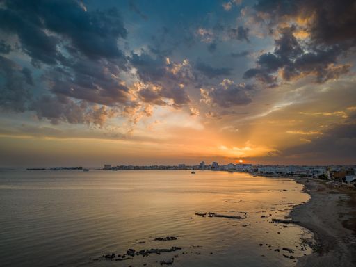 An aerial view of seaside cityscape of Porto Cesareo in Italy during bright cloudy sunset