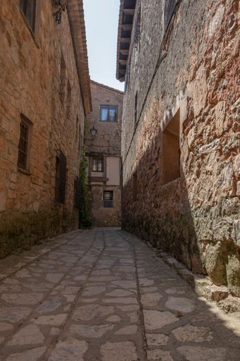 A vertical low-angle shot of a narrow alley in Spain, Medinaceli in the province of Soria