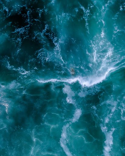 Aerial drone top view of surfer practicing in wavy blue sea ,of a tropical exotic island, Sydney Australia