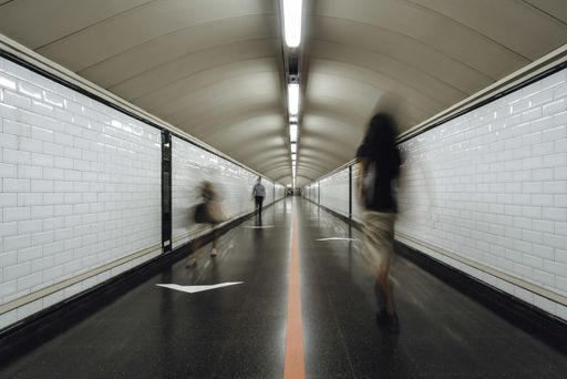 A group of people rushing through a subway corridor