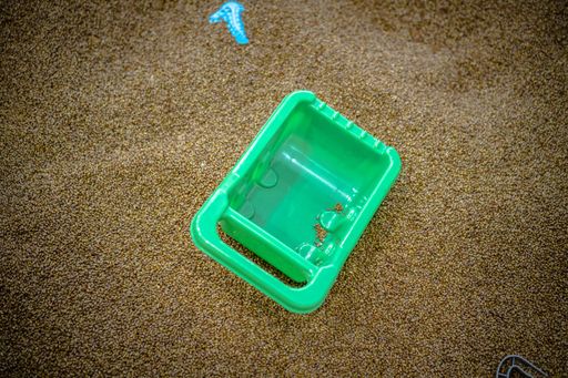 A close-up shot of a plastic toy in a black sand